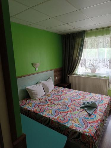 a bedroom with a bed with a colorful bedspread at Хостел Ритон in Ruse