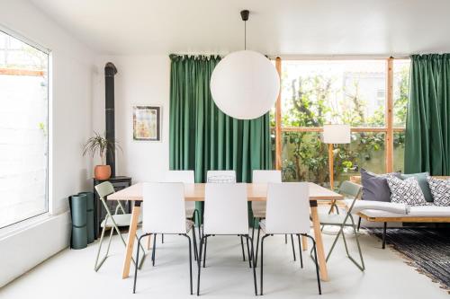 a dining room with green curtains and a table and chairs at 4BR, Garden & BBQ, 5min to Milícias Beach, Easy Park, Casa Yucca in São Roque