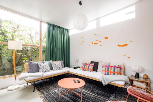 a living room with a couch and a table at 4BR, Garden & BBQ, 5min to Milícias Beach, Easy Park, Casa Yucca in São Roque