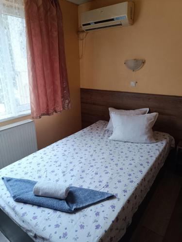 a bedroom with a bed with two towels on it at Хостел Ритон in Ruse