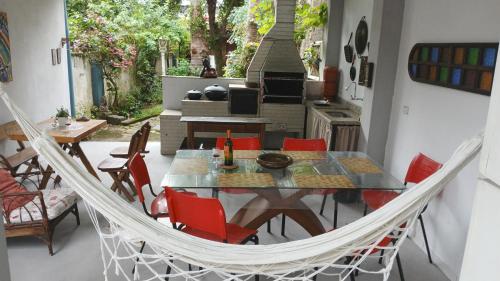 a dining room with a hammock and a table and chairs at Muito espaço e natureza no meio da cidade in Santos