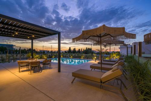 a patio with a table and chairs and a pool at Mama Rosa Luxury Villas with private pools in Zipárion