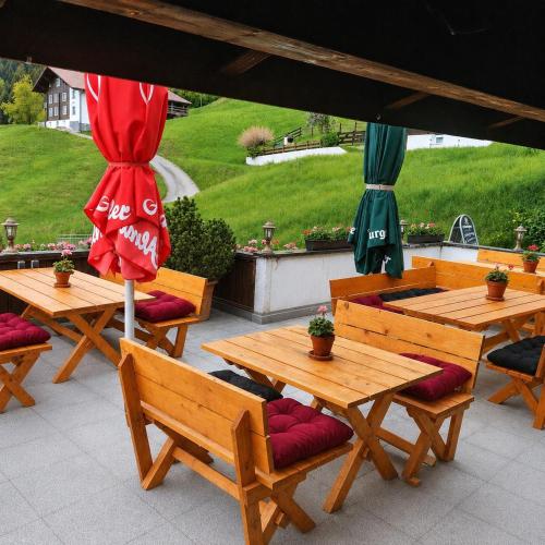 two tables and benches with umbrellas on a patio at Alpinchalet Zigjam in Gaschurn