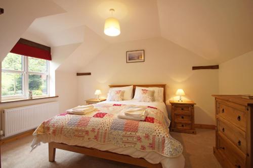 a bedroom with a bed and two lamps and a window at Hen Gapel in Aberhosan