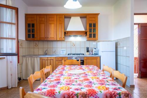 a kitchen with a table with a flowered table cloth at Passeggiata Alla Spiaggia in Campo nell'Elba