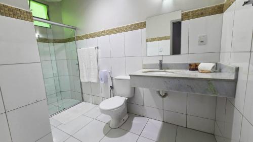 a bathroom with a toilet and a sink and a shower at Bandeirantes Hotel in Cuiabá