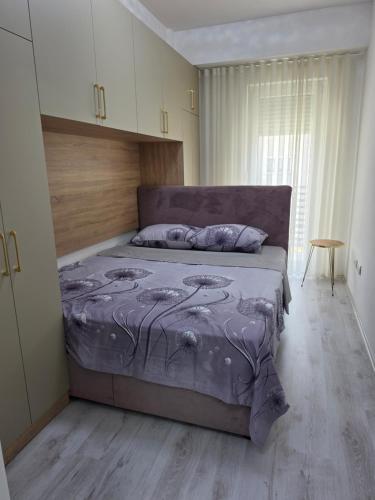 a bedroom with a bed with a purple comforter at Lux Apartman Gostivar in Gostivar