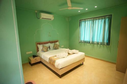 a bedroom with a bed in a green room at Amorae Resort in Loni Khurd