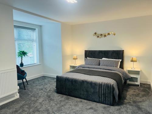 a bedroom with a king sized bed and a window at Luxurious New Home Near Airport in Wythenshawe