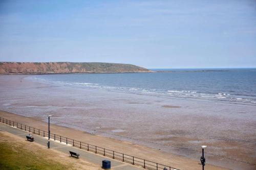 a beach with a fence next to the ocean at Host & Stay - The Beach in Filey
