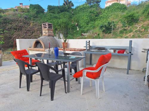 a table and chairs with a table and an oven at LASSI Apartment 1 in Argostoli