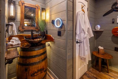 a bathroom with a wooden barrel sink and a wooden door at "Air Fort One" Aviation-Themed Luxury Treehouse Near Dollywood & Pigeon Forge in Sevierville