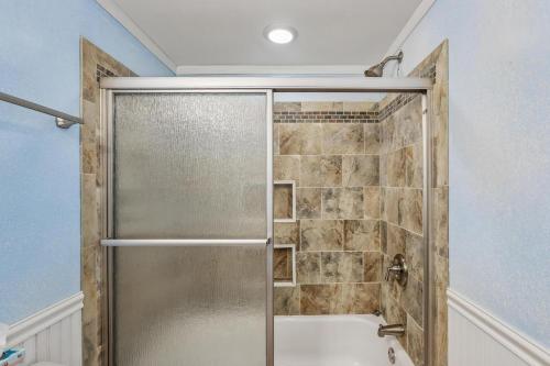 a shower with a glass door in a bathroom at The Gallery in Kitty Hawk
