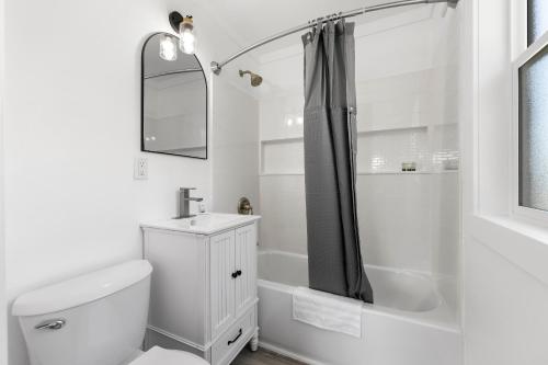 a bathroom with a toilet and a sink and a shower at Copper Hill Suites in Butte