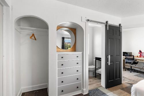 a bedroom with a dresser and a mirror at Copper Hill Suites in Butte