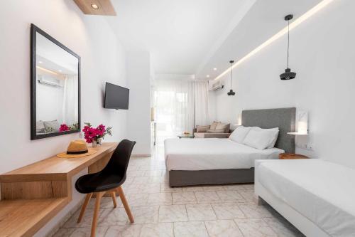 a bedroom with a bed and a desk with a chair at Elvita beach hotel in Lartos