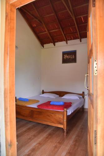 a bedroom with a bed with blue pillows on it at Hillwoods homestay in Somvārpet