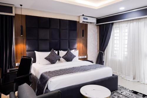 a bedroom with a large bed with a black headboard at BON Hotel Kabuwol in Ibadan