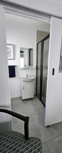 a white bathroom with a sink and a mirror at Sonrisa on Point in Stompneusbaai