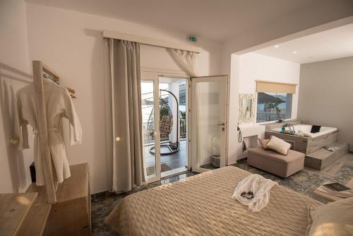 a bedroom with a bed and a chair and a mirror at Hyperion Hotel in Myrties