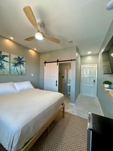 a bedroom with a bed and a ceiling fan at Sandbar Beachfront Hotel & Hostel Restaurant in San Pedro