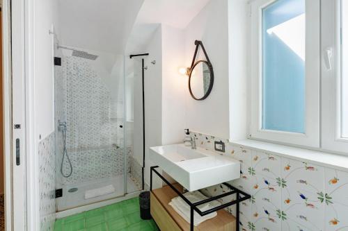 a white bathroom with a sink and a shower at La Casa Del Bosco - Two floors home in Naples