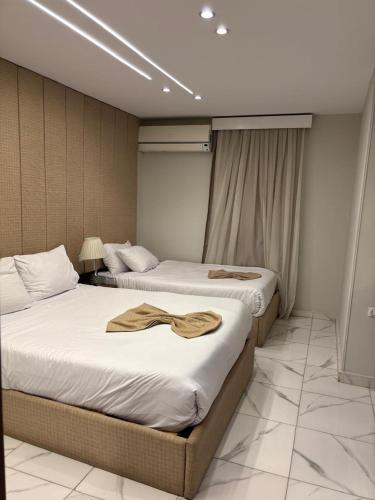 two beds in a hotel room with towels on them at Hermes On The Spot Pyramids Hotel in Cairo