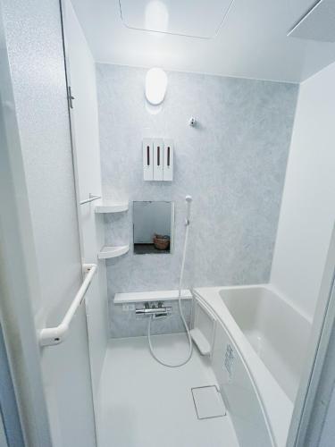 a white bathroom with a sink and a tub at Telegraph in Kamakura