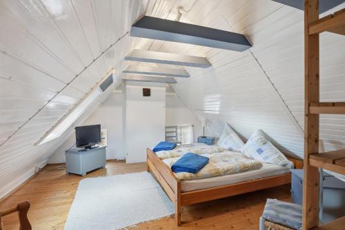 a bedroom with a bed and a tv in a attic at Kieke Wiet in Greetsiel