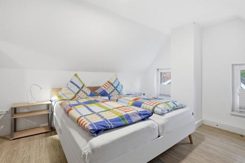 a white bed with pillows on it in a room at Kiek In in Greetsiel