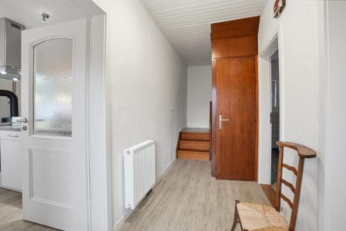 a room with a hallway with a door and a chair at Kiek In in Greetsiel