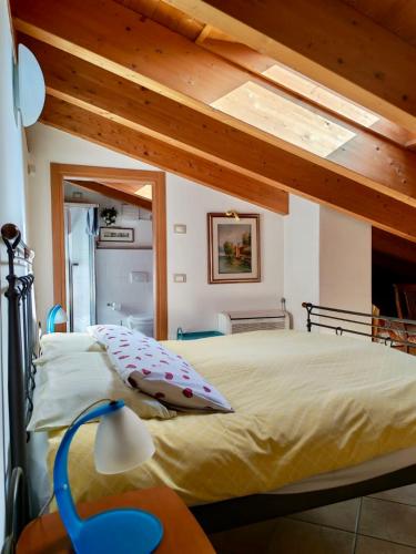 a bedroom with a large bed with a wooden ceiling at Camera Lucy in Bardolino