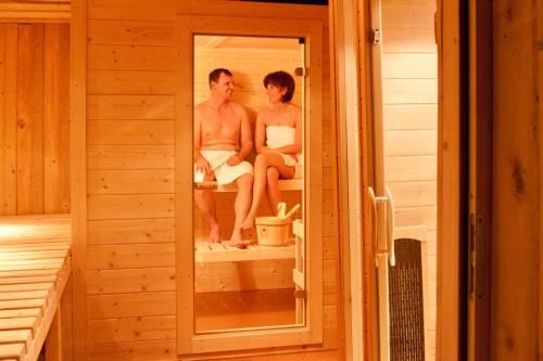 a man and a woman sitting in a sauna at Der Perweinhof in Donnersbachwald