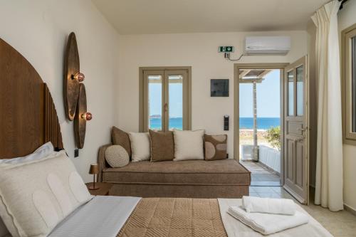 a bedroom with a couch and a view of the ocean at Iliovasilema Studios in Mytakas