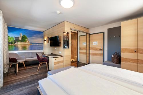 a hotel room with a bed and a bathroom at Hotel-Restaurant Schwedi in Langenargen