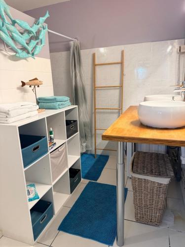 a bathroom with a sink and a wooden table at Bleu Caraibe studio in Schœlcher