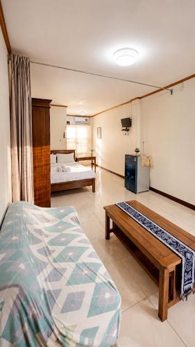 a room with two beds and a couch in it at Ocha Bajo Homestay in Komodo Labuan Bajo Airport