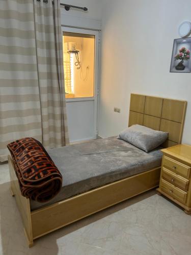 a bedroom with a bed and a window with a shower at Appartement Berkane in Berkane