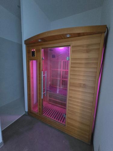 eine große Holztür in einem Raum mit rosa Lichtern in der Unterkunft L' Ecrin in Auch