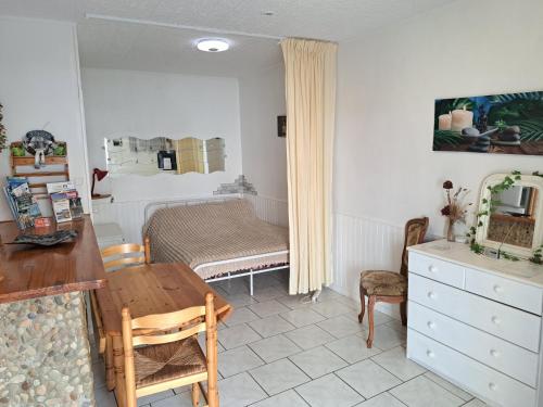 a living room with a table and a bedroom at Studio cosy entre Mer, Espagne & Montagne in Peyrestortes