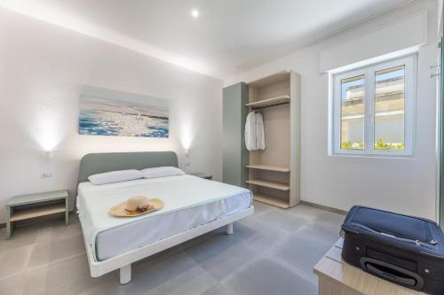 a bedroom with a bed with a hat on it at Appartamenti Mancaversa in Marina di Mancaversa