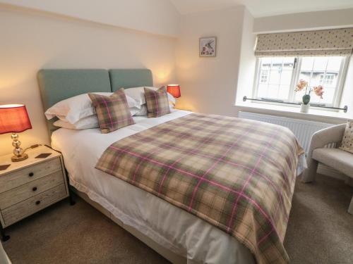 a bedroom with a bed and a chair and a window at The Toll Bar in Castleton