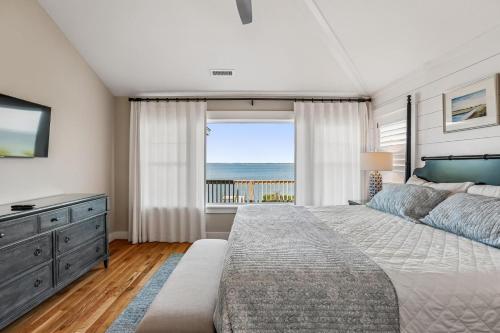 a bedroom with a bed and a view of the ocean at Knot for Sail in Duck
