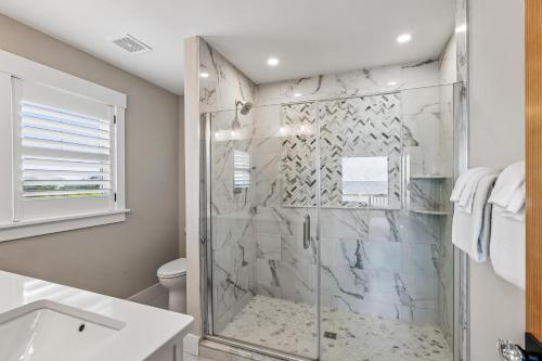a bathroom with a shower with a glass door at Knot for Sail in Duck