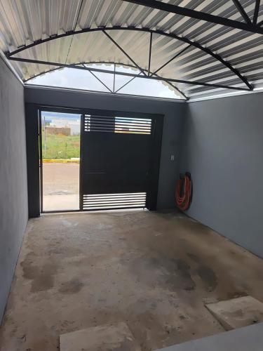 a garage with a black door and a window at Espaço Aconchegante e Moderno in Primavera do Leste