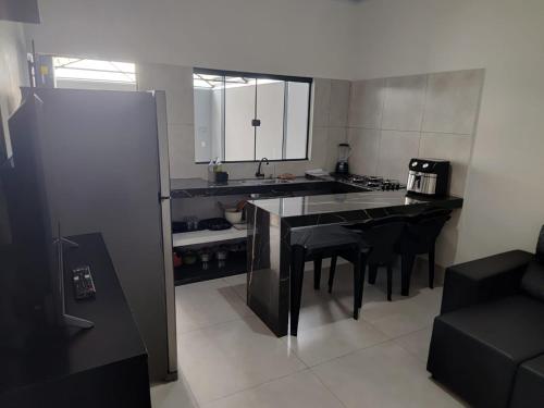 a kitchen with a table and black chairs in it at Espaço Aconchegante e Moderno in Primavera do Leste