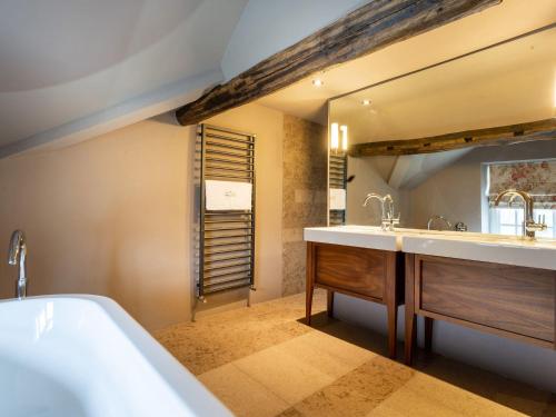 a bathroom with a tub and a sink and a mirror at Prospect House in Windermere