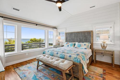 a bedroom with a bed and two windows at Sanctuary in Duck