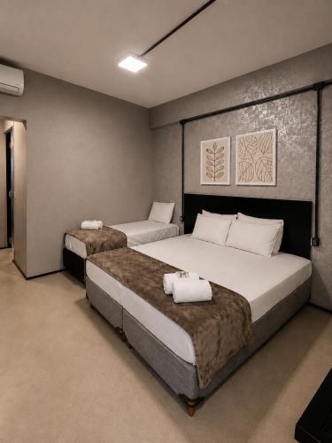 a bedroom with two beds with white pillows on them at ADD Hóteis Congonhas in São Paulo