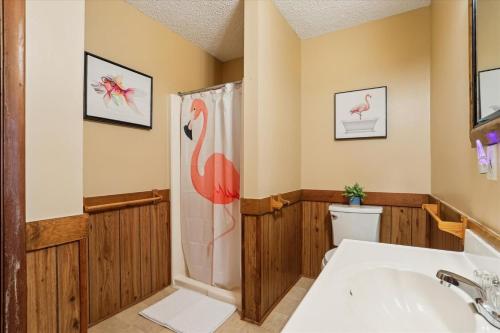 a bathroom with a tub and a pink flamingo shower curtain at Doris's Day in Duck